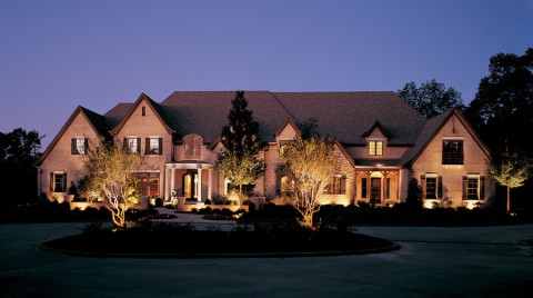 A house in Missouri with dramatic landscape lighting enhancing the front of the property. 