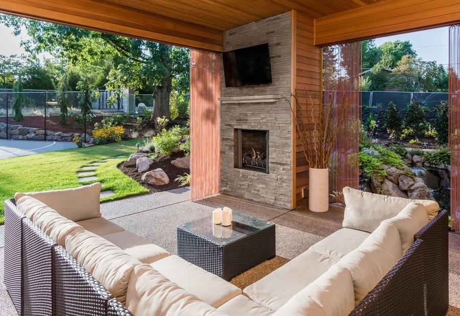 An outdoor space featuring seating and a mounted outdoor TV