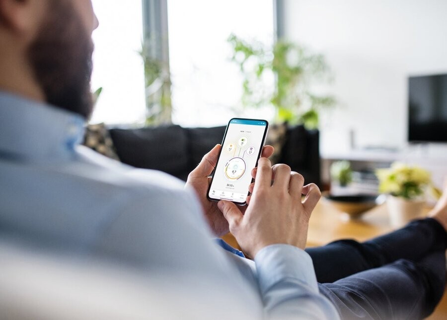  A man managing his home’s energy usage on his smartphone’s Savant Power app.