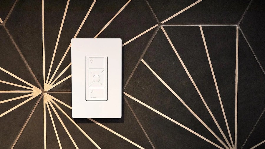 Lutron wall-mounted lighting control switch installed on a geometric-patterned wall.