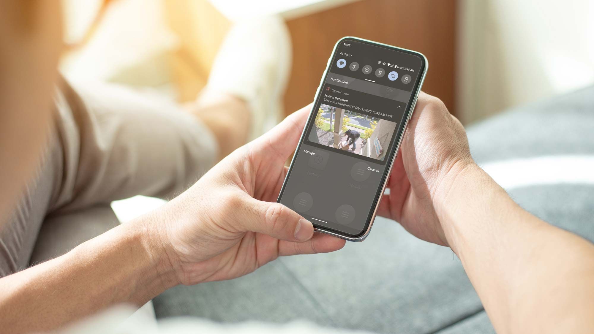 woman holding phone with control4 interface on it