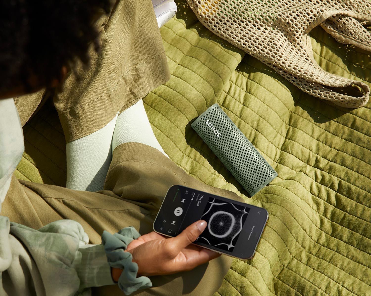 Woman Playing with AirPlay in her Sonos Roam in green