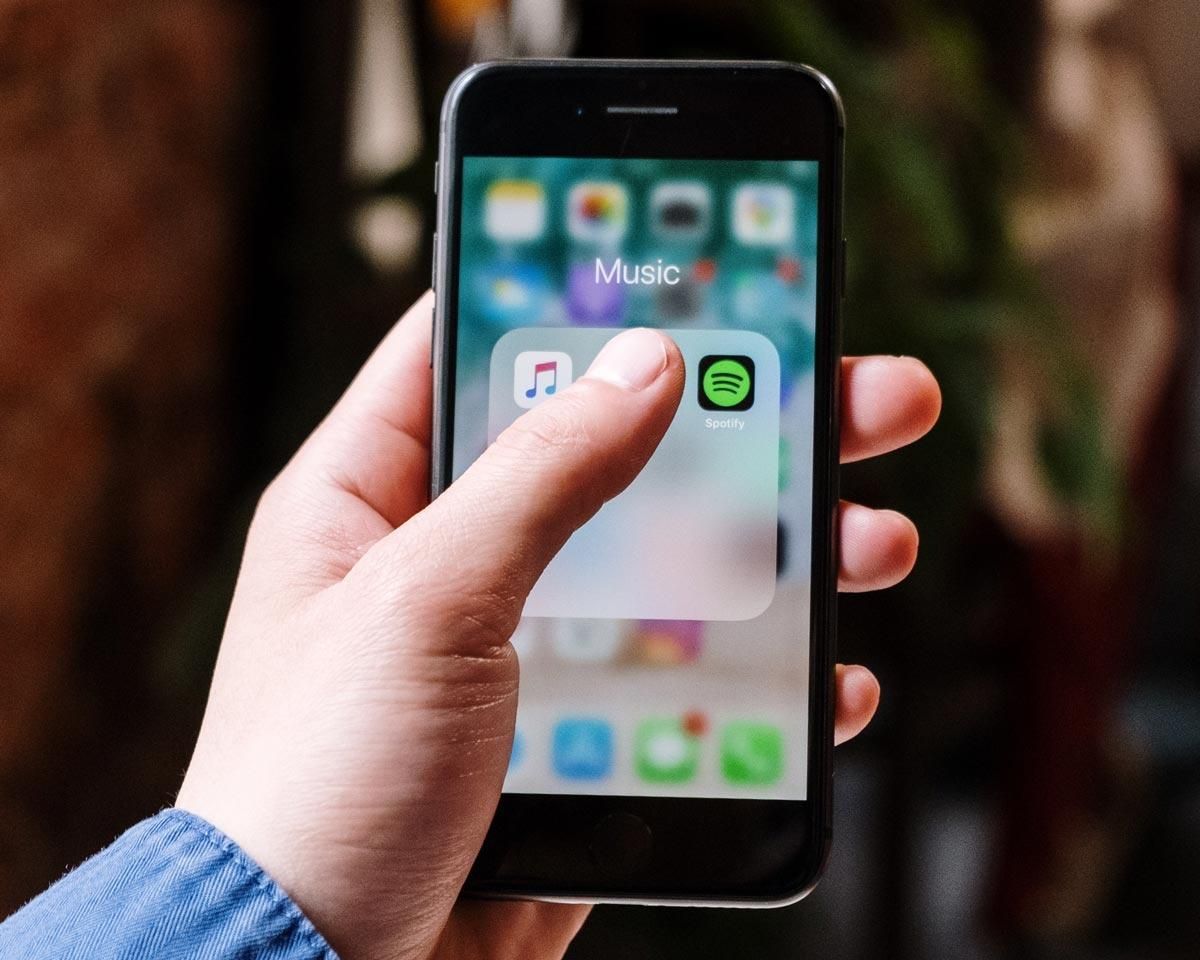 Man's hand touching an iPhone app to open